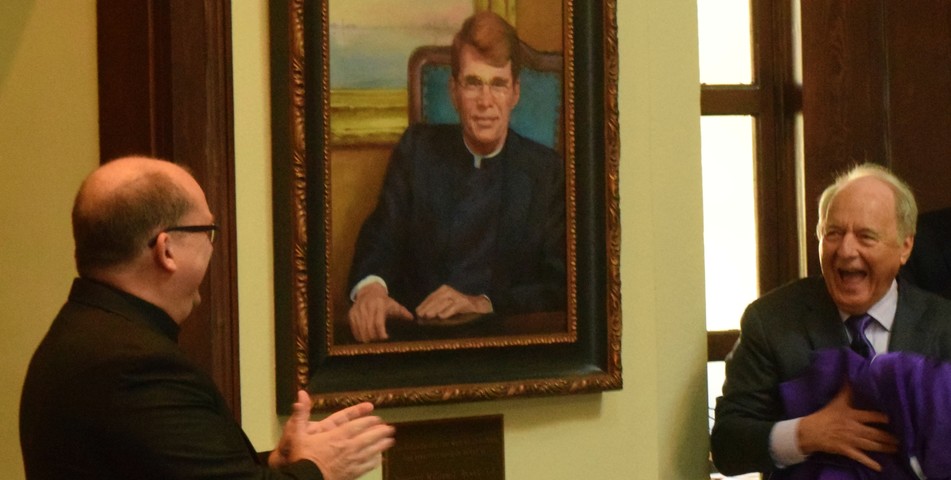 Samm Brown: SHC President Dr. Christopher Puto, right, and Fr. Mark Mossa, S.J., at left, react at the unveiling of a portrait of the Rev. William J. Rewak S.J. The unveiling celebrated the naming of the Rotunda in honor of Rev. Rewak.