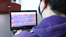 Student looks at Diversity & Inclusion Week flyer. (photo: BessMorgan Bayulut)